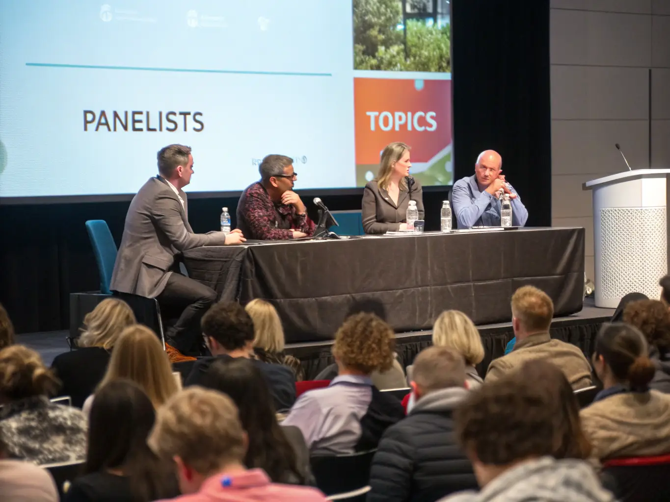 A dynamic image showcasing a panel discussion at a Cape Town tech conference, with panelists representing various sectors of the tech industry. The backdrop includes the iconic Table Mountain.